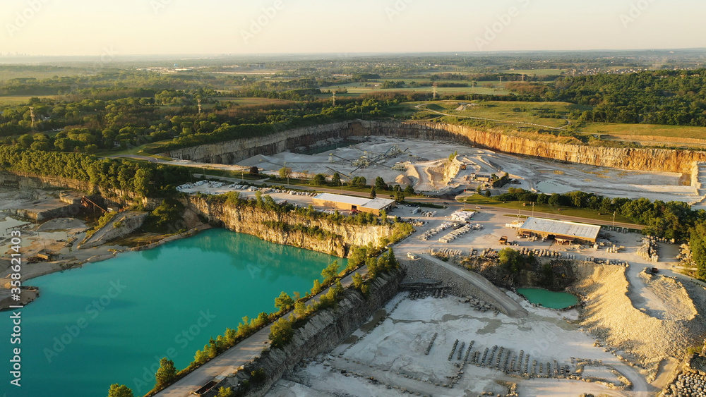 Aerial view of Stone Plant. Quarrying and manufacturing of natural stone products for building, construction, landscaping purposes. Industrial landscape, turquoise water, summertime, early morning, su