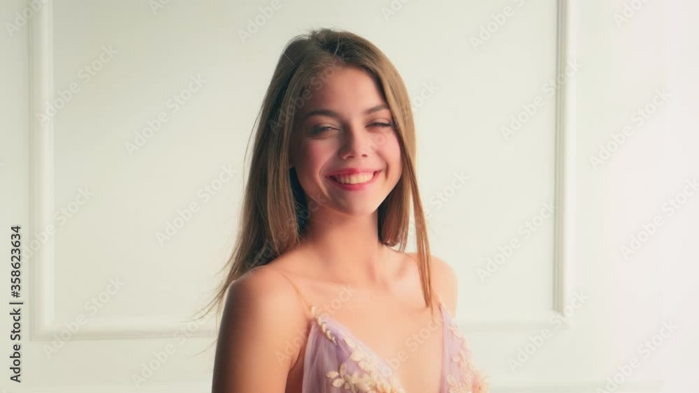 portrait young happy beautiful cute young woman. long flowing hair fluttering, fly in wind. sexy girl laughs joyfully. Gentle natural makeup, pink lips gray eyes, smiling face. white room interior portrait young happy beautiful cute young woman. long flowing hair fluttering, fly in wind. sexy girl laughs joyfully. Gentle natural makeup, pink lips gray eyes, smiling face. white room interior