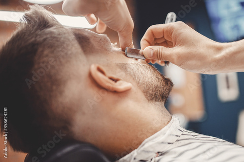 Man hipster having barber shave razor blade barbershop