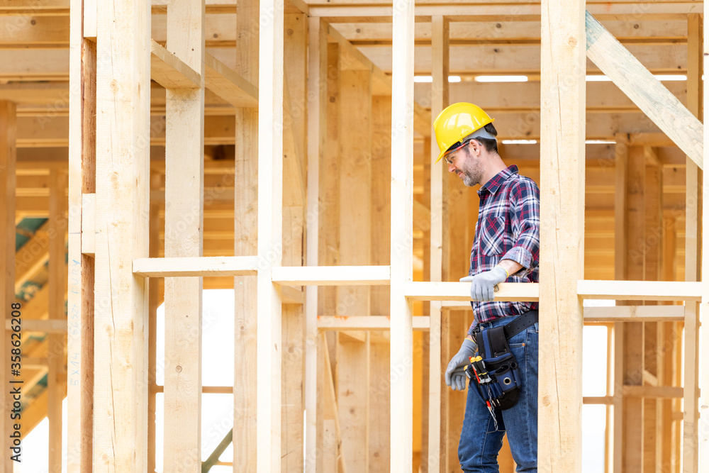 Builder worker on construction site of frame house Builder worker on construction site of frame house