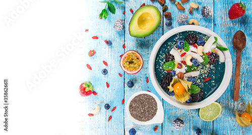 Smoothie bowl with fresh berries, nuts, seeds, fruit and vegetables. Healthy breakfast.