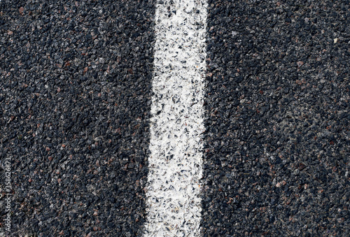 Gray grungy asphalt. Asphalt road surface with a white strip. View from above.