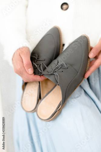gray stylish and modern women s loafers on a layout  in the hands of a girl  shoes on toes  trendy photos of shoes