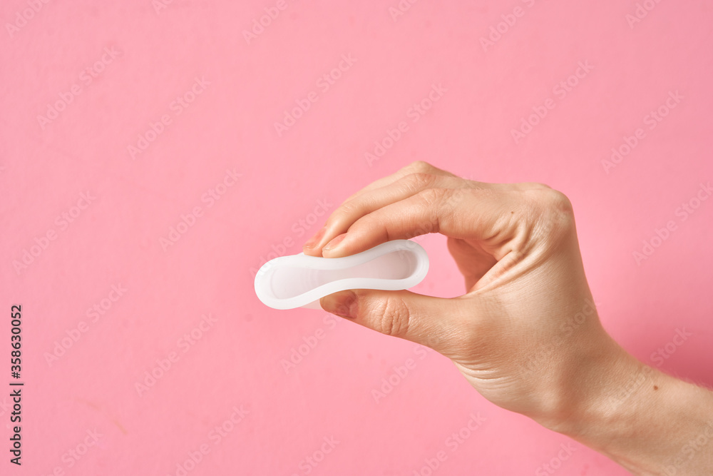 Menstrual cup eco friendly reusable and silicone in woman's hand isolated on a white background Menstrual cup eco friendly reusable and silicone in woman's hand isolated on a white background