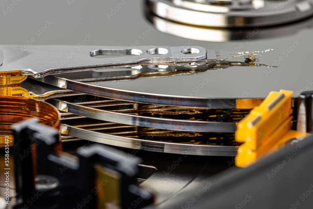 Macro photo of a magnetic needle on a hard disk, an open HDD with three plates. Macro photo of a magnetic needle on a hard disk, an open HDD with three plates.