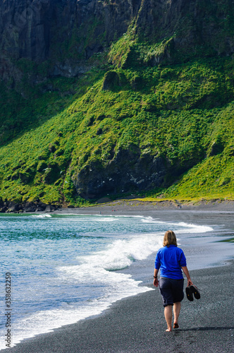 Woman walking on the beach. Vik, Iceland © Mikael