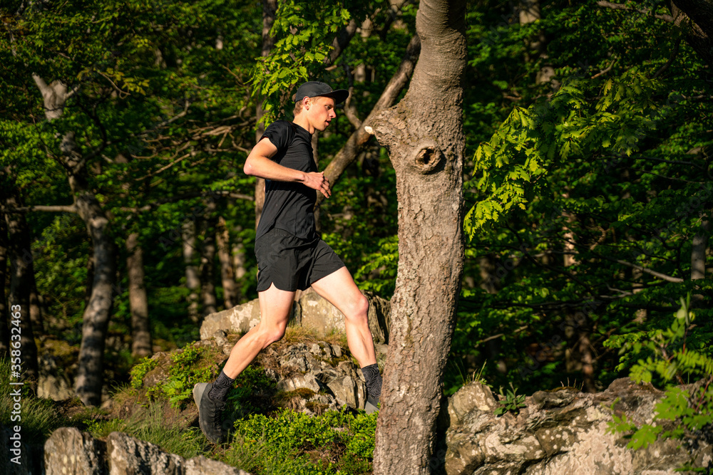 Trail Runner runs down the rocky mountains Trail Runner runs down the rocky mountains