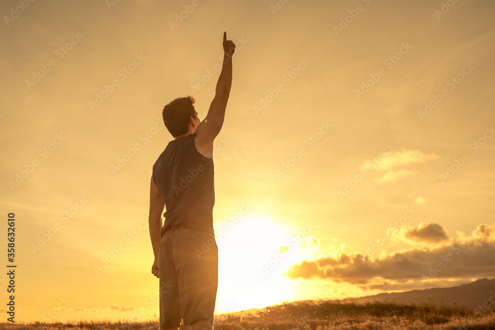 People winning, victory concept. Strong confident man outdoors raising arms in the air making number one sign.