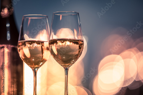 two glasses of wine on table with beautiful bokeh lights background 