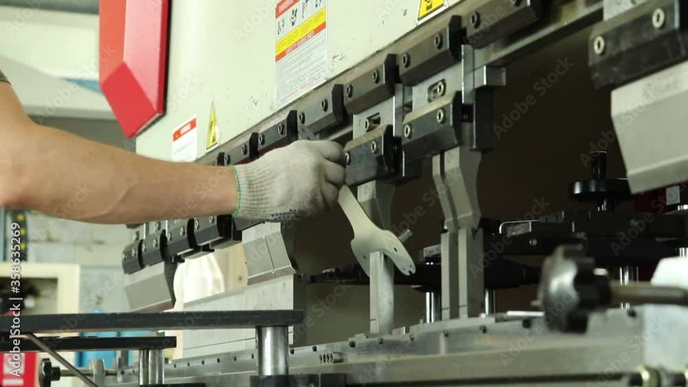 The operator of the bending machine, bends the part on the machine with a pre-programmed program. Worker works at a metalworking plant