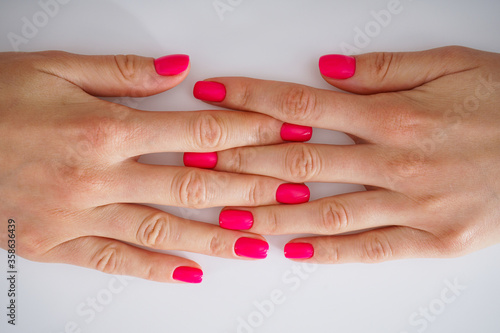 Beauty and skin care concept  close-up. Beautiful hands of a young woman and beautiful manicure on a white background  flat-lay.