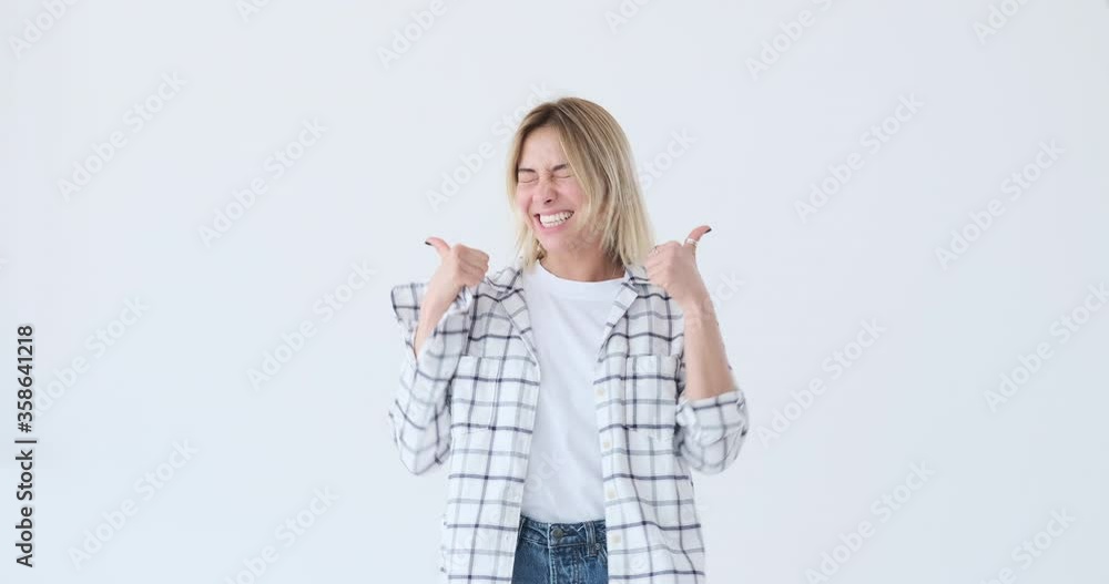 Excited woman giving thumbs up gesture and celebrating success over white background Excited woman giving thumbs up gesture and celebrating success over white background