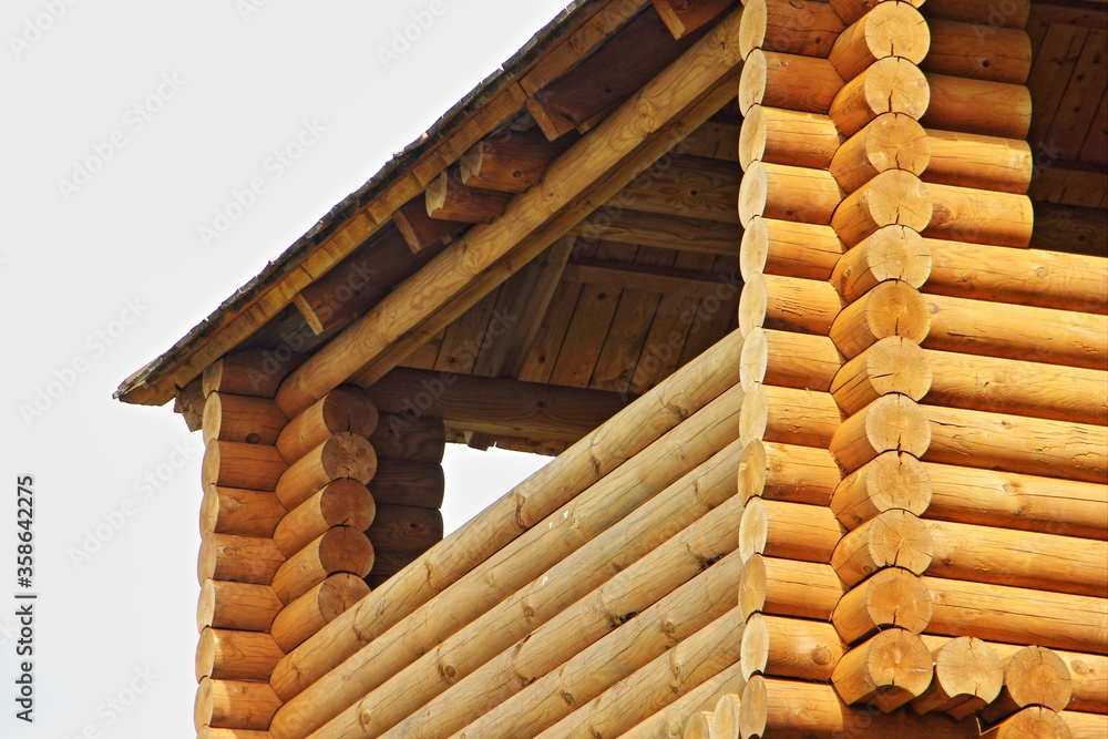 Fototapeta premium New wooden home, russian style country house with balcony fragment close up on a sunny summer day
