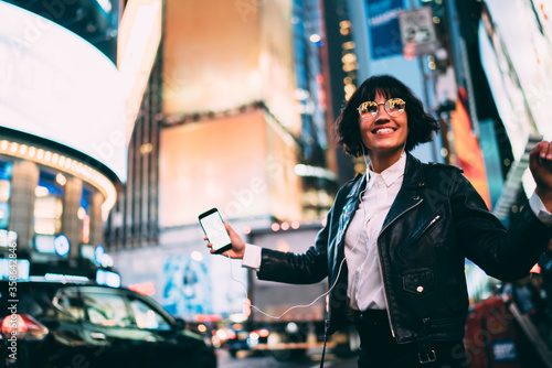 Photography Cheerful woman in fashionable clothing listening positive music for relaxing in