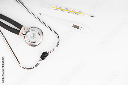 Stethoscope with thermometer on white background. Device for listening to lungs.