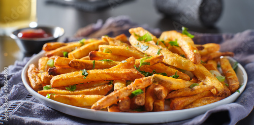 plate of crispy seasoned french fries with parsley garnish