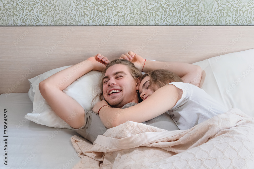 beautiful married couple lies hugging in bed, life together, relationship in a pair beautiful married couple lies hugging in bed, life together, relationship in a pair