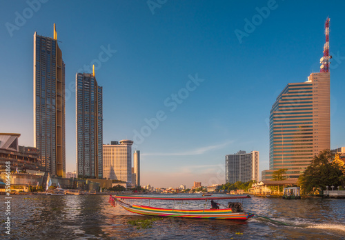 Canvas Print Skyscrapers and Traditional Long Tail Speedboat on the Chao Phraya River in Bang
