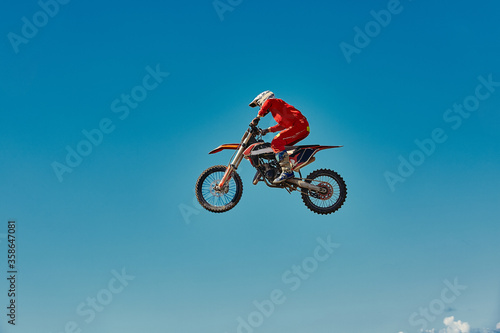 Motocross concept  a biker goes off-road making extreme skiing. In pursuit of adrinalin  sport concept. Dangerous sport.