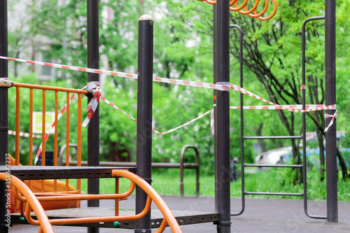 The play park of amusement and sports for young children is wrapped in red barrier tape. Outside. Prohibition of outdoor walks, prevention of the covid-19. moscow. selective focus