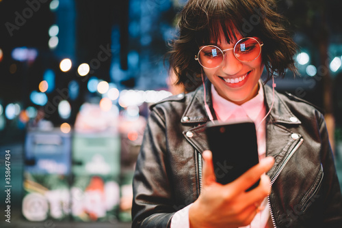 Photography Cheerful female blogger share photos of night city in networks satisfied with in