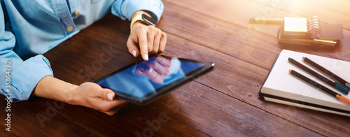 Woman pointing on digital tablet screen, chatting in social networks, meeting website, searching internet, sending sms, using text messenger or online banking. Close up photo photo