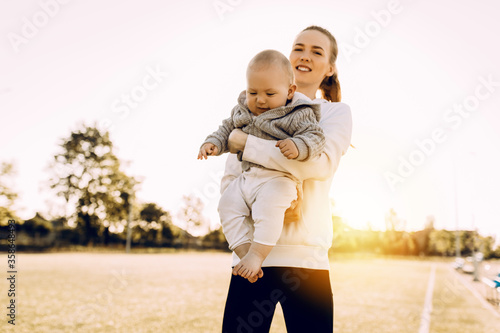 Young beautiful mom and her little son at sunset