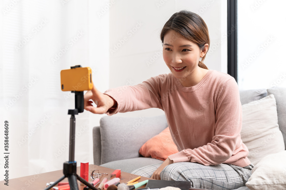 Asian woman blogger live steam video of makeup cosmetic at home online influencer on social media concept
Asian woman blogger live steam video of makeup cosmetic at home online influencer on social media concept