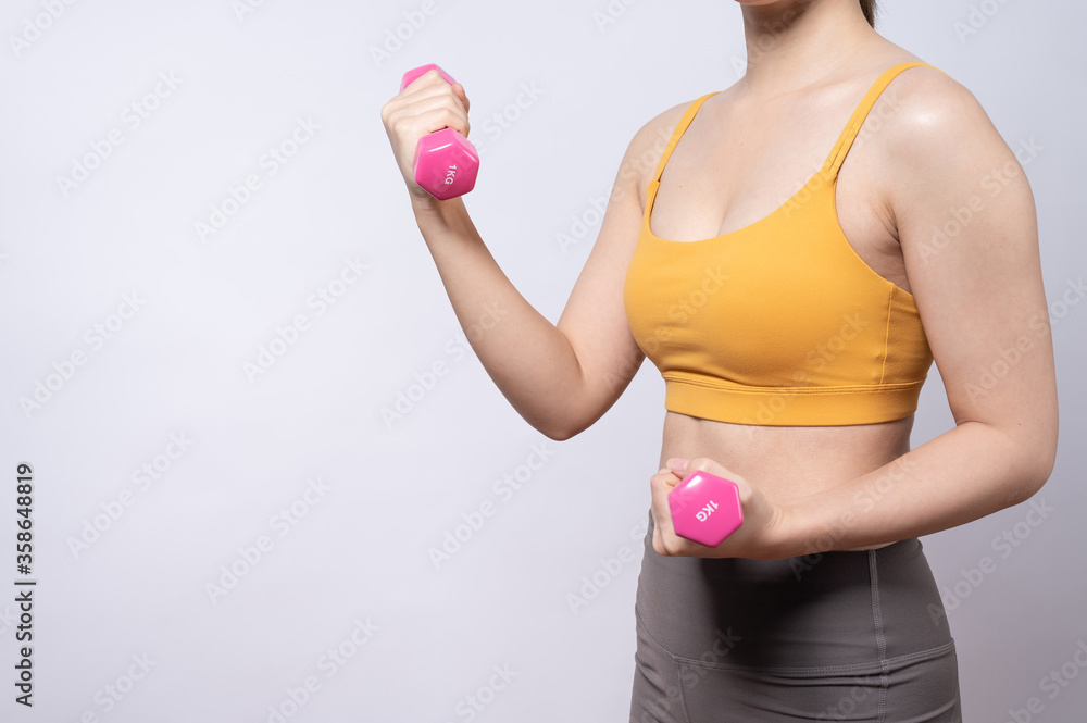 Asian sporty woman with a dumbbell fit slim body isolated on white background. concept of a healthy lifestyle Asian sporty woman with a dumbbell fit slim body isolated on white background. concept of a healthy lifestyle