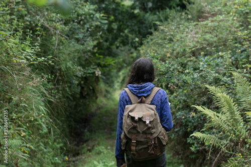 Wallpaper Mural girl from the back with backpack and blue sweatshirt walking through the forest in Asturias, lots of vegetation Torontodigital.ca