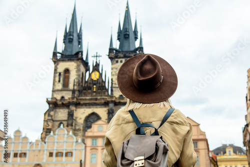 Blonde woman in hat and backpack at central square in Prague, Czech Republic