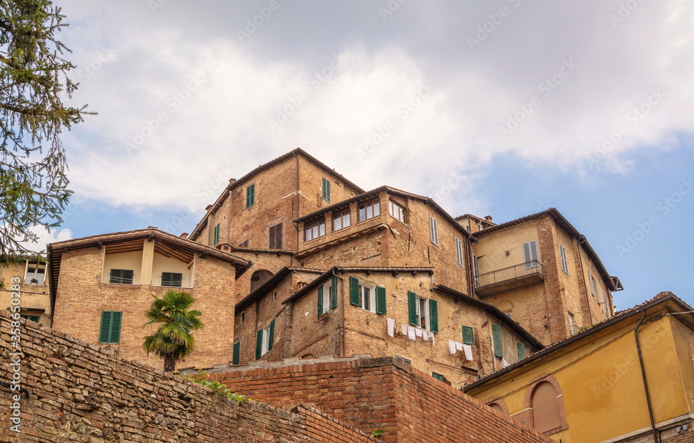 Ancient residential buildings on  hill in Italian city of Siena