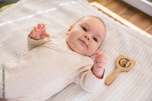 Newborn baby two-months-old smiles and lies on a white blanket. Psychomotor development and baby care photo