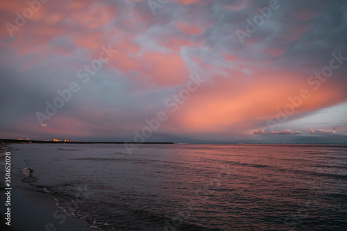 Tableau sur toile A view to sea at sunset . Pink sky and clouds .