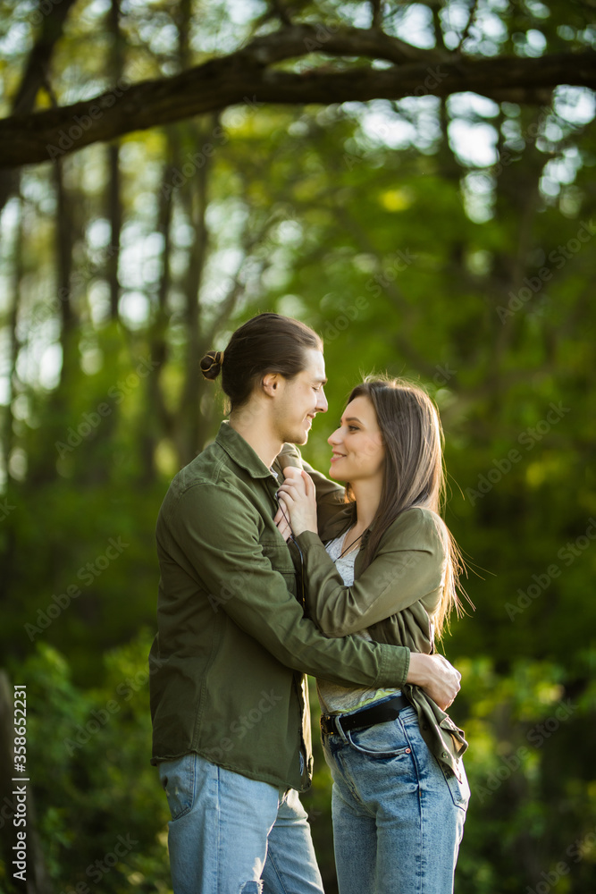 Happy young couple hugging and laughing outdoors in the park Happy young couple hugging and laughing outdoors in the park