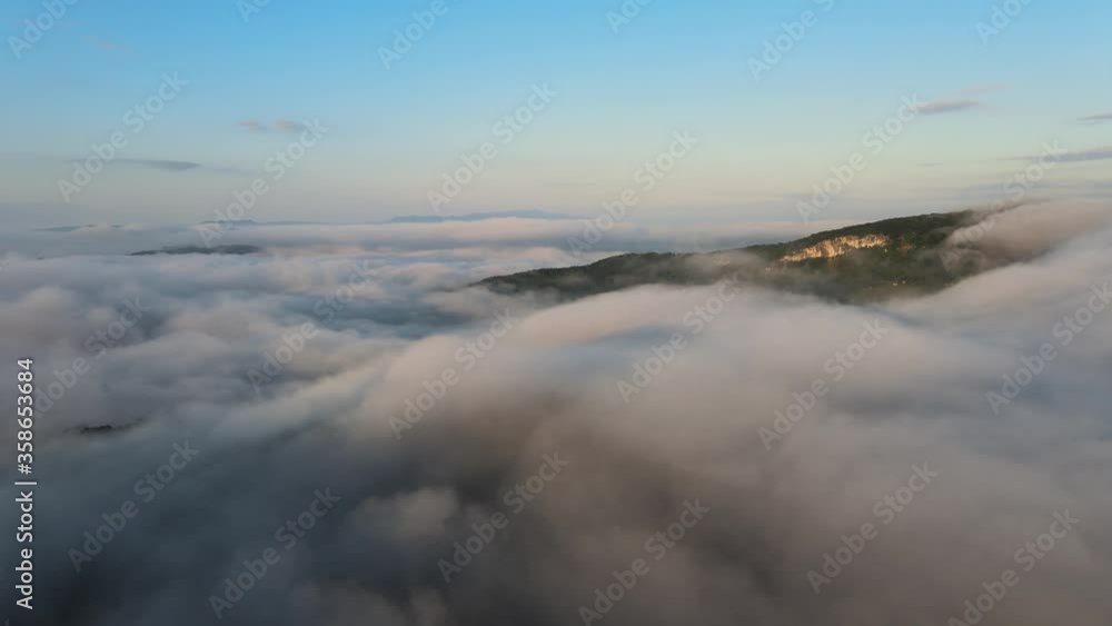 Drone flying over the white blanket of thick dense clouds covering the mountains. Aerial. Drone flying over the white blanket of thick dense clouds covering the mountains. Aerial.