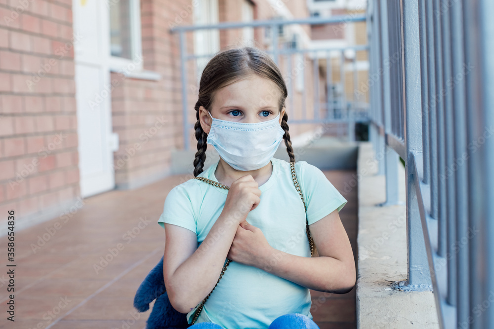 a girl in a mask with two pigtails with sad eyes is sitting on the porch of the entrance a girl in a mask with two pigtails with sad eyes is sitting on the porch of the entrance