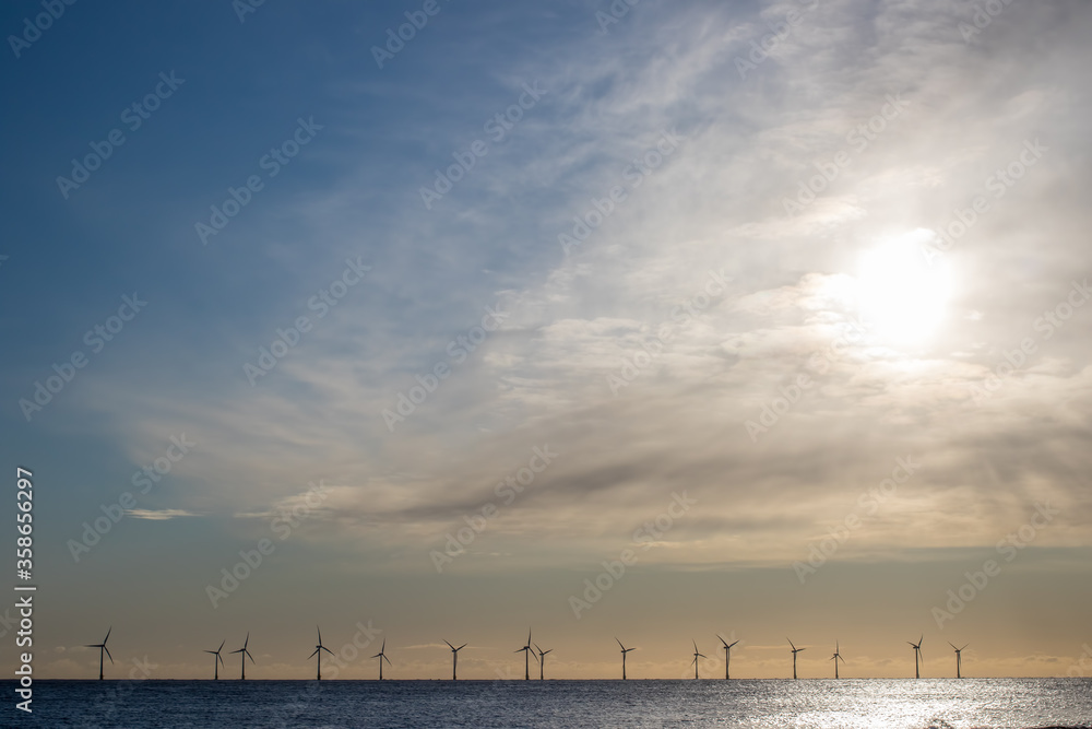 Offshore wind farm turbines on the sea horizon. Background landscape border image Offshore wind farm turbines on the sea horizon. Background landscape border image