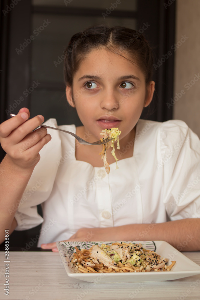Little girl in a white dress eats in the kitchen Little girl in a white dress eats in the kitchen