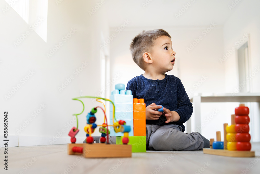 Small boy three or four years old playing on the floor at home - Little caucasian child spending free time alone with brick blocks and creative toys - creativity childhood care growing up concept Small boy three or four years old playing on the floor at home - Little caucasian child spending free time alone with brick blocks and creative toys - creativity childhood care growing up concept