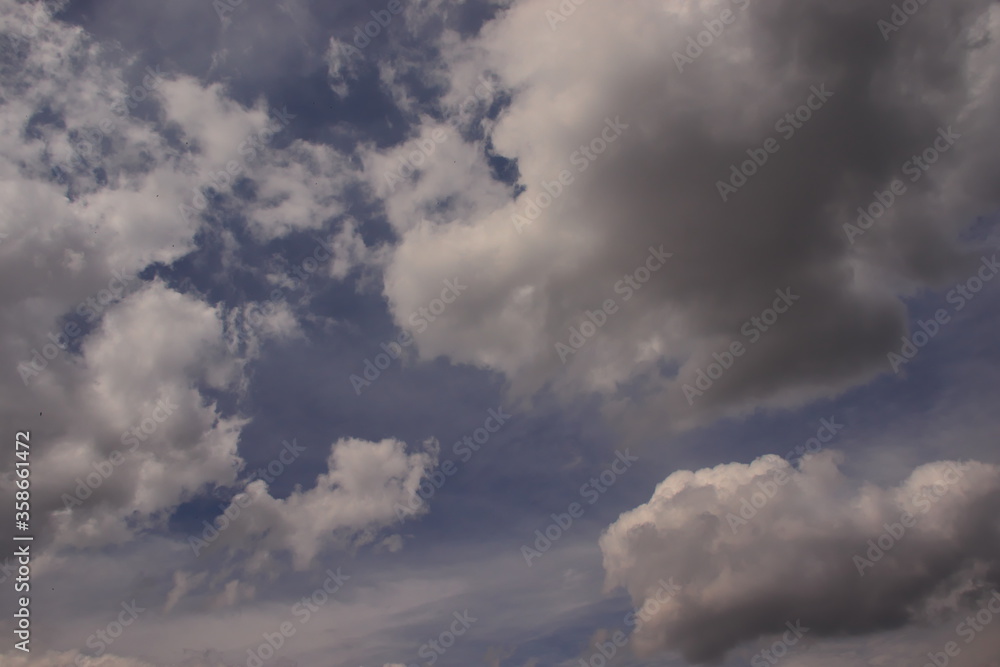 little fluffy white cumulus clouds floating together in a heavenly blue sky covered by a fine mist. little fluffy white cumulus clouds floating together in a heavenly blue sky covered by a fine mist.