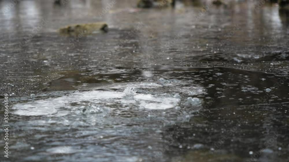Stone fall on ice with strong splash water breaks frozen surface slow motion. Strong spray frozen river winter closeup. Streams water explode under ice drop stone slow motion. Powerful splashing river Stone fall on ice with strong splash water breaks frozen surface slow motion. Strong spray frozen river winter closeup. Streams water explode under ice drop stone slow motion. Powerful splashing river