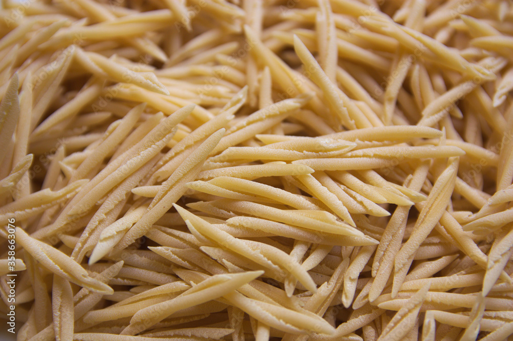 Closeup of a plate of uncooked italian pasta called trofie Closeup of a plate of uncooked italian pasta called trofie