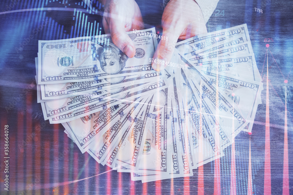 Multi exposure of financial graph drawing hologram and USA dollars bills and man hands. Analysis concept. Multi exposure of financial graph drawing hologram and USA dollars bills and man hands. Analysis concept.