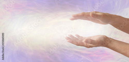 Channelling beautiful soft golden healing energy between hands - parallel female hands on right with energy flowing across 
