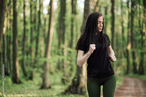 Young sporty woman running in forest