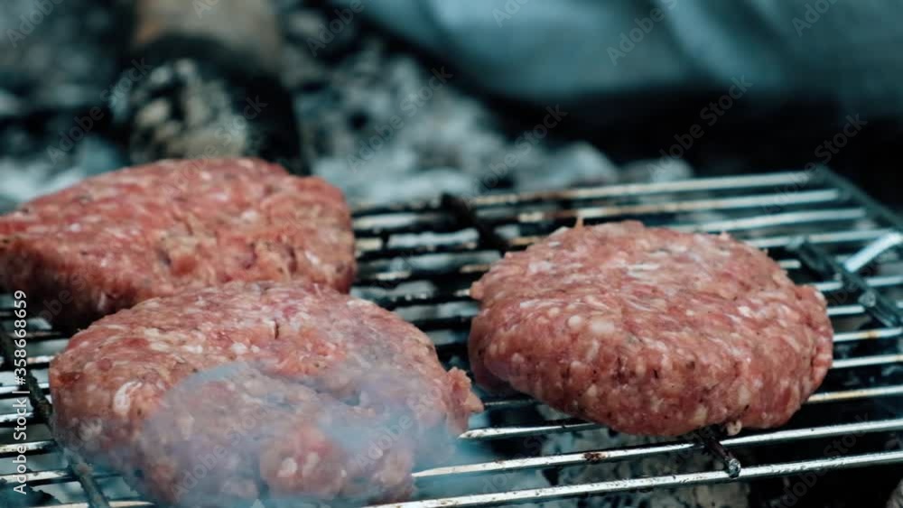 Raw burgers cooked on campfire in the woods Raw burgers cooked on campfire in the woods