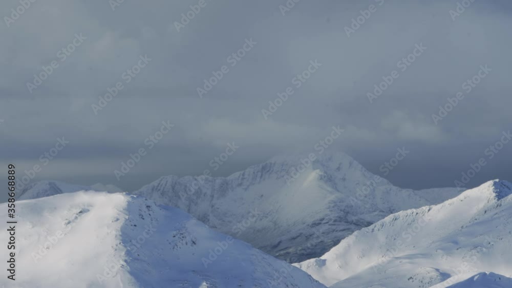 Static shot of mountain with clouds slowly moving past with smaller mountains in the foreground. Static shot of mountain with clouds slowly moving past with smaller mountains in the foreground.