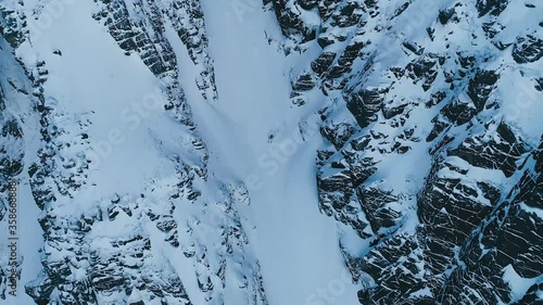 Aerial view of backcountry skier carving his way down steep narrow Scottish gully in the Nevis range.