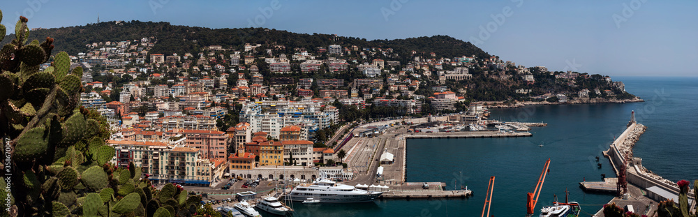 Panoramic View of Part of Nice City Port in France with Boats Berth Added Lighthouse Cape and City Buildings on Hill - Houses Yachts and Sea in Port Lympia in Summer